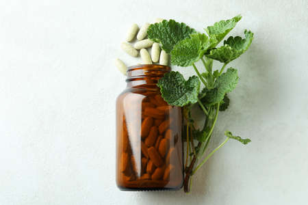 Bottle with herbal pills on white textured background, top viewの写真素材