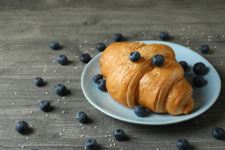 Plate with croissant and blueberry on gray textured tableの写真素材