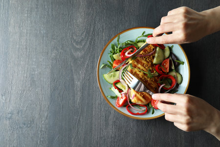 Concept of tasty eating with salad with grilled chicken on dark textured tableの写真素材