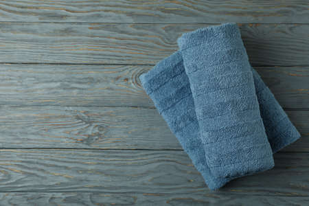 Clean folded towels on gray wooden table, space for textの写真素材