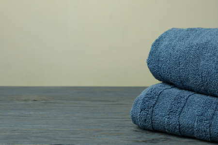 Clean folded towels on gray wooden table, space for textの写真素材