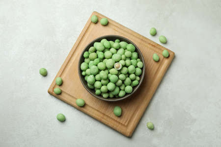 Board with bowl of wasabi nuts on white textured backgroundの写真素材