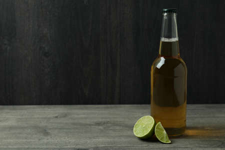Bottle of beer and lime against dark wooden backgroundの写真素材