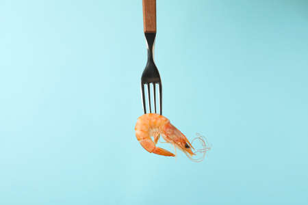 Fork with tasty shrimp on blue backgroundの写真素材