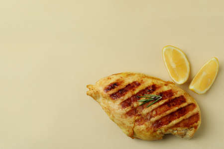 Grilled chicken meat and lemon on beige backgroundの写真素材