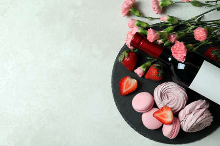 Sweet food and blank wine bottle on white textured backgroundの写真素材