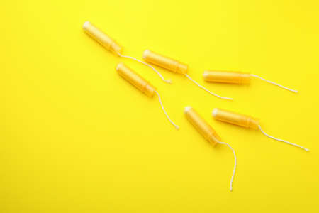 Orange tampons on yellow background, space for textの写真素材