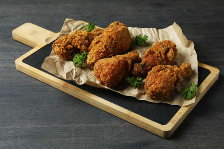 Concept of tasty eating with fried chicken on dark wooden backgroundの写真素材