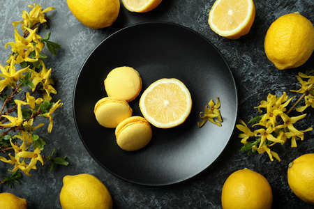 Macaroons, lemons and flowers on black smokey backgroundの写真素材