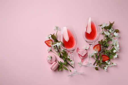Wine, macaroons, strawberry and flowers on pink backgroundの写真素材