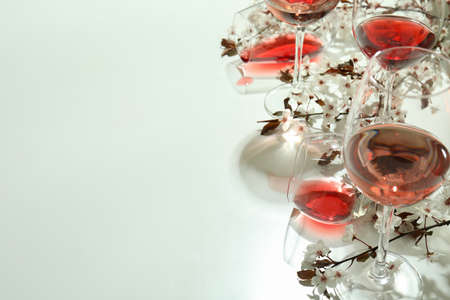 Glasses of wine and cherry flowers on white backgroundの写真素材