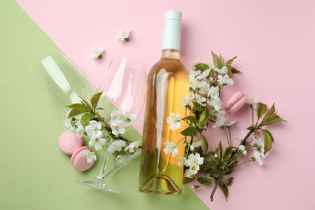 Wine, macaroons and flowers on two tone backgroundの写真素材