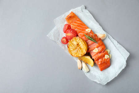Concept of tasty eating with grilled salmon on gray background