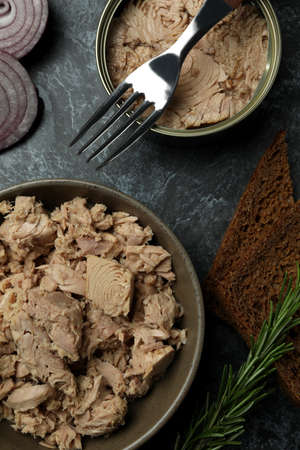 Concept of tasty eating with canned tuna on black smokey background