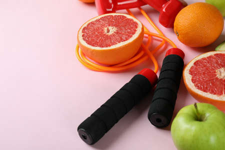 Healthy lifestyle accessories on pink background, space for text
