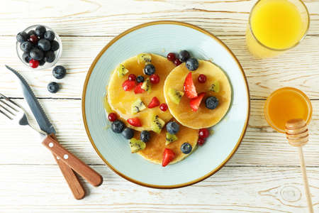 Concept of delicious dessert with pancakes on white wooden tableの写真素材