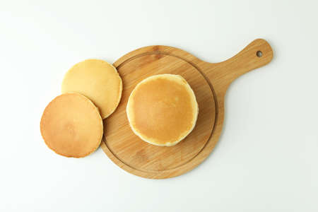 Board with tasty pancakes on white tableの写真素材