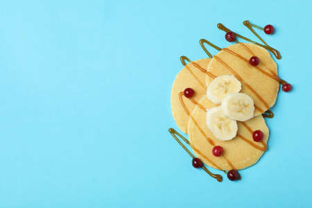 Pancakes with cranberry, banana and caramel on blue backgroundの写真素材