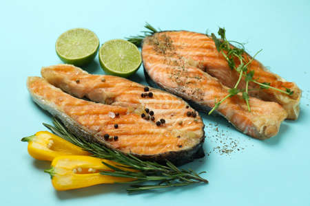 Tasty grilled salmon and ingredients on blue backgroundの写真素材