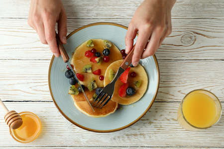Concept of delicious dessert with pancakes on white wooden table