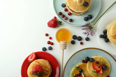 Concept of delicious dessert with pancakes on white background