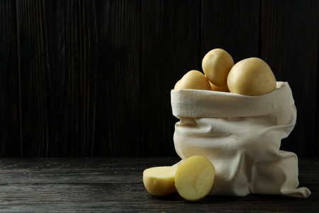 Bag of young potato on wooden tableの写真素材