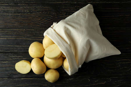 Bag of young potato on wooden tableの写真素材