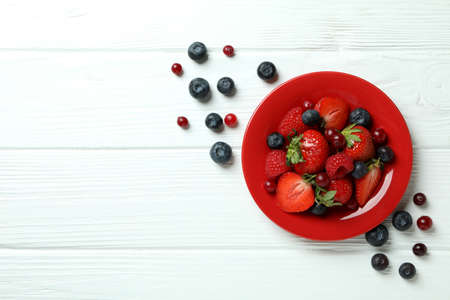 Bowl with berry mix on white wooden backgroundの写真素材