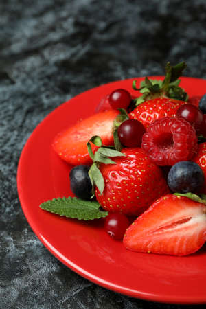 Plate with berry mix on black smokey backgroundの写真素材