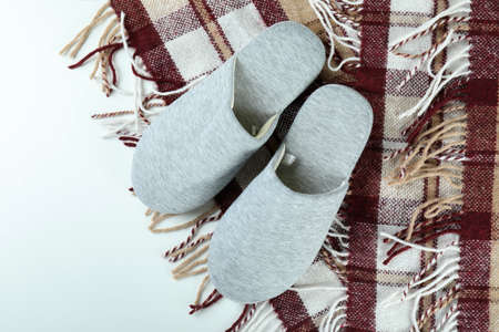 Pair of house slippers and plaid on white backgroundの写真素材