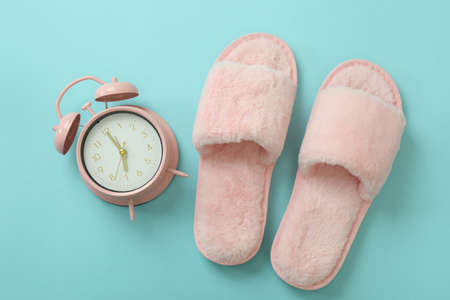 Alarm clock and slippers on blue backgroundの写真素材