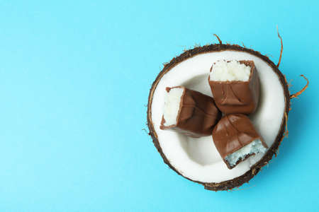 Coconut with candy bars on blue backgroundの写真素材