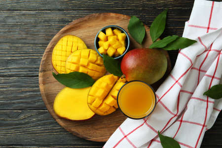 Ripe mango fruit and juice on wooden tableの写真素材