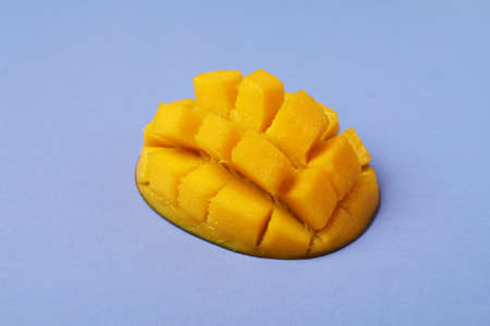 Tasty ripe mango fruit on violet backgroundの写真素材