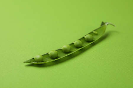 Green pea pod with seeds on green backgroundの写真素材