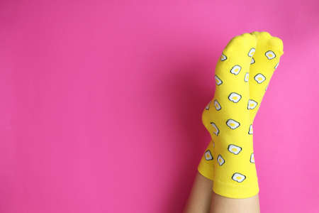 Female legs in funny socks on pink backgroundの写真素材