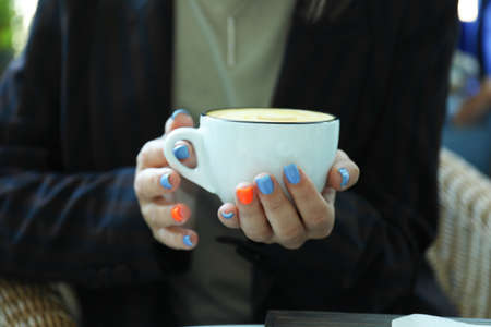 Woman holds cup of delicious coffee, close upの写真素材
