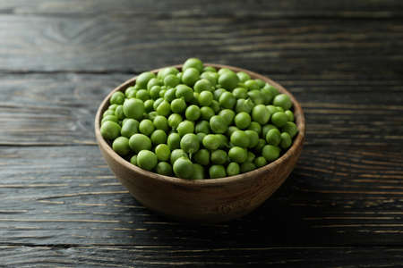Bowl with pea seeds on wooden backgroundの写真素材