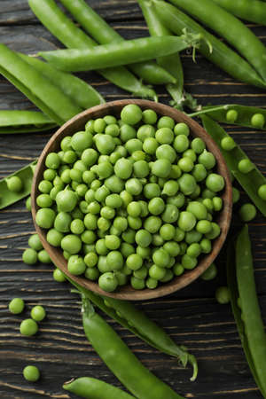 Bowl with fresh pea seeds on wooden backgroundの写真素材