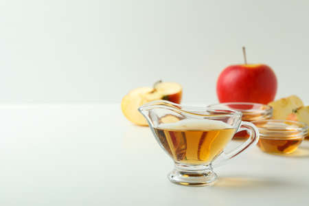 Homemade apple vinegar and ingredients on white tableの写真素材