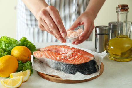 Concept of cooking salmon on white textured backgroundの写真素材