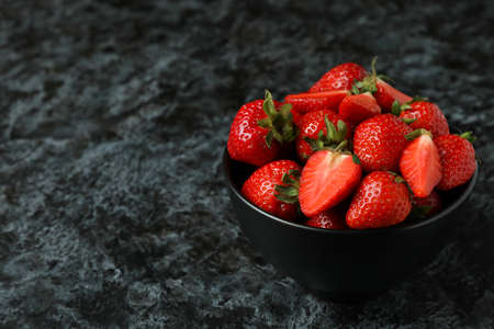 Bowl of fresh strawberry on black smokey background
