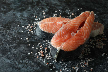Fresh raw salmon and salt on black smokey backgroundの写真素材