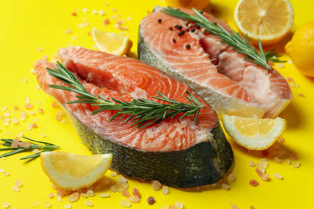 Fresh raw salmon and spices on yellow backgroundの写真素材