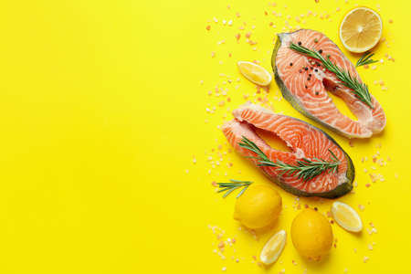 Fresh raw salmon and spices on yellow backgroundの写真素材