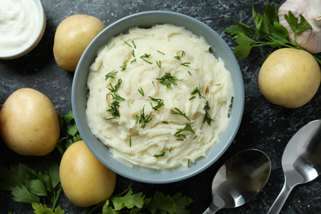 Concept of tasty eating with mashed potatoes on black smokey table