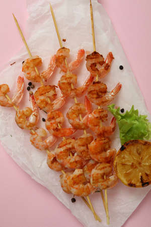 Tasty grilled shrimps skewers on pink backgroundの写真素材