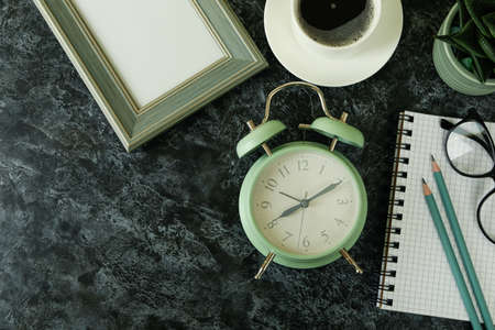 Workplace concept with alarm clock on black smokey background