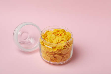 Jar of corn flakes on pink backgroundの写真素材
