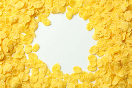 Dry uncooked corn flakes on white background, space for textの写真素材